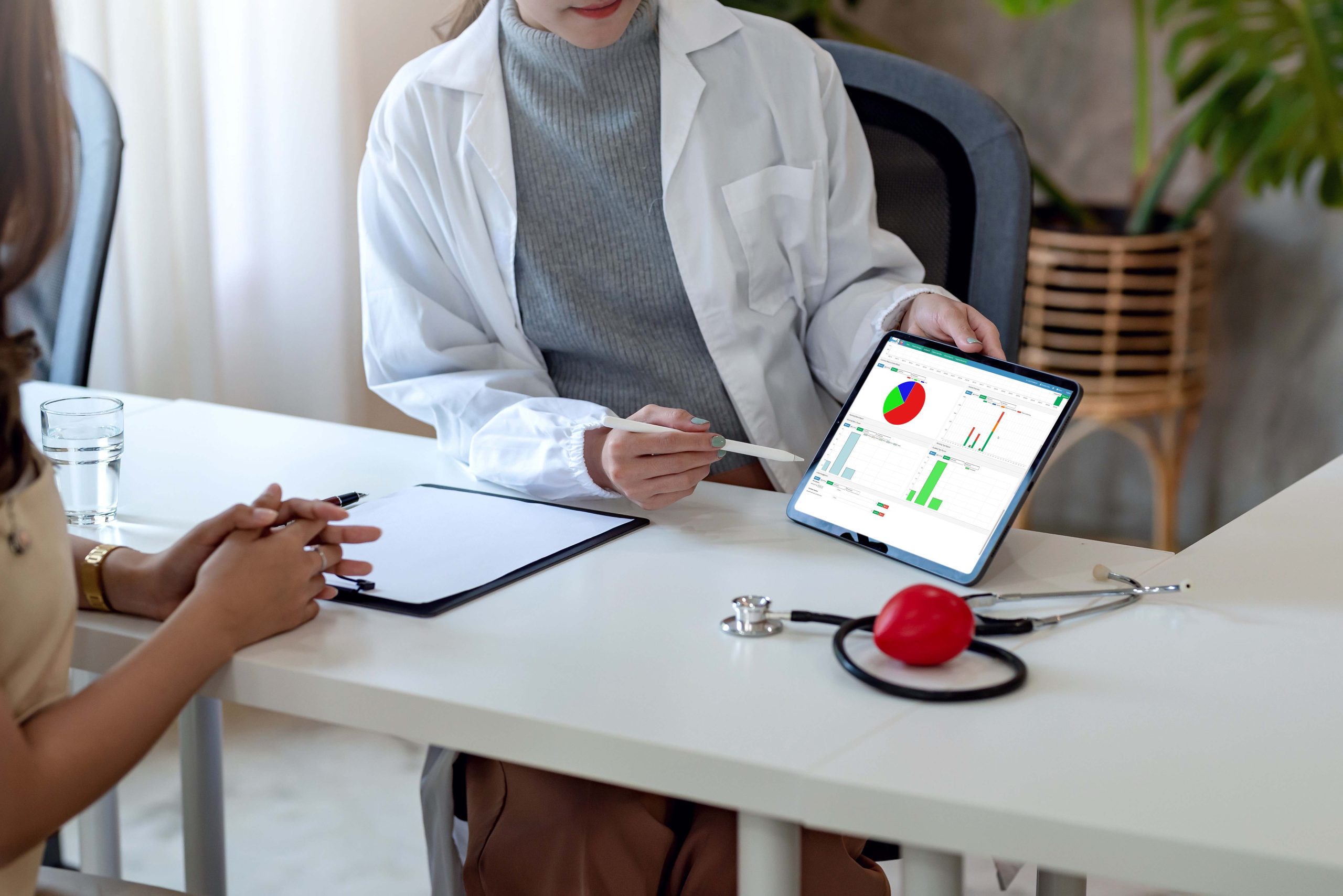 Doctor discussing records with patient using digital tablet blank white screen.
