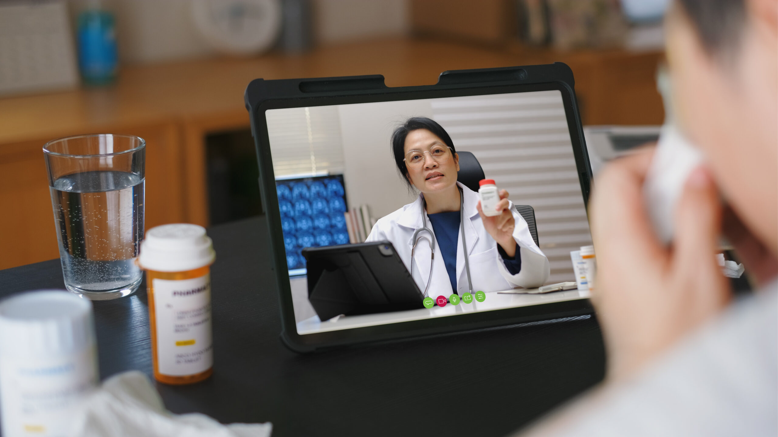 Doctor doing a telemed consultation with a patient over a tablet.