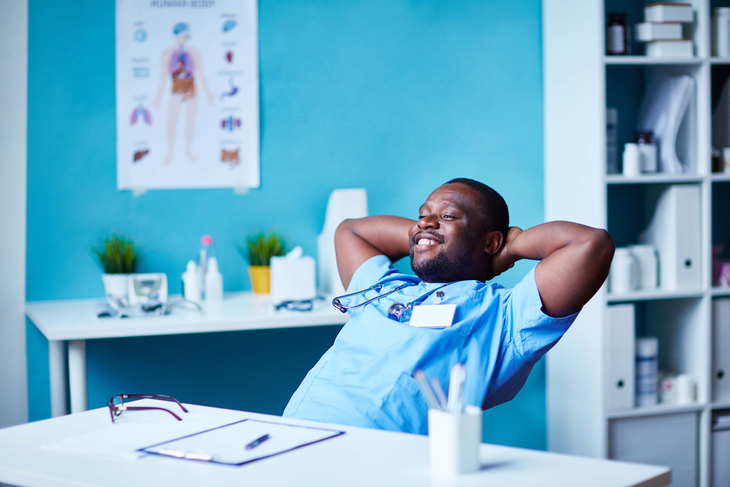 African male doctor with arms behind head